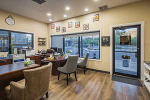 Office area featuring visible vents, baseboards, wood finished floors, and recessed lighting