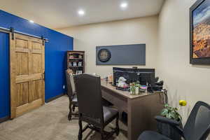Carpeted office space with a barn door, baseboards, and recessed lighting