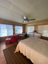 Bedroom with ceiling fan, wood finished floors, and multiple windows