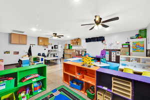 Playroom with a textured ceiling, visible vents, and a ceiling fan