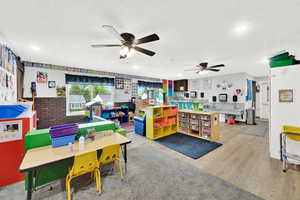 Recreation room with recessed lighting, a textured ceiling, a ceiling fan, and wood finished floors