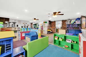 Game room with a barn door, ceiling fan, and recessed lighting