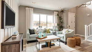 Living room with recessed lighting, stairway, baseboards, light wood-type flooring, and a notable chandelier
