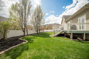 View of yard with a fenced backyard, a wooden deck, and stairs
