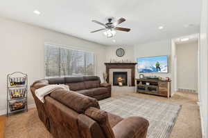 Living room with recessed lighting, visible vents, ceiling fan, a tile fireplace, and baseboards