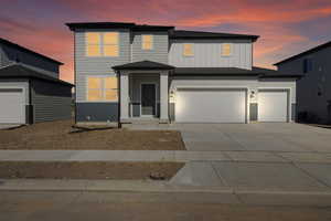 View of front facade with a garage, board and batten siding, and concrete driveway