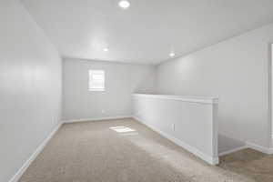 Basement with baseboards, light carpet, and recessed lighting