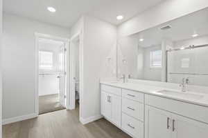 Full bathroom featuring toilet, visible vents, a shower stall, and a sink