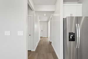 Hallway with baseboards, recessed lighting, and wood finished floors