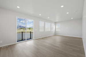 Spare room with light wood-style floors, recessed lighting, baseboards, a water view, and visible vents