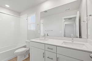 Bathroom with a sink, toilet, and visible vents