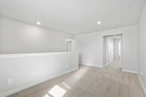 Carpeted spare room with recessed lighting and baseboards
