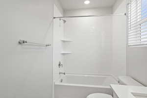 Bathroom with recessed lighting, vanity, toilet, and shower / washtub combination