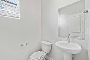 Bathroom featuring a sink, baseboards, and toilet