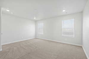 Carpeted spare room featuring recessed lighting, baseboards, and visible vents