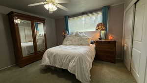 Bedroom featuring multiple windows, ceiling fan, baseboards, and light carpet