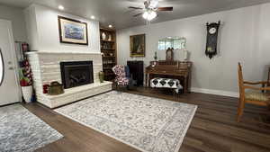 Living room with recessed lighting, a fireplace, a ceiling fan, baseboards, and wood finished floors