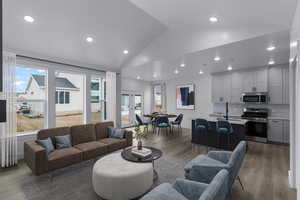 Living area featuring wood finished floors, recessed lighting, and high vaulted ceiling