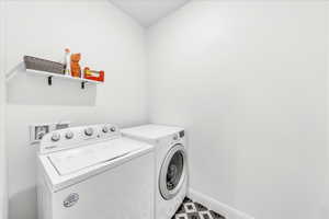 Washroom featuring laundry area, baseboards, and washer and dryer