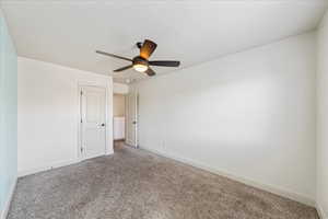 Carpeted spare room with baseboards and a ceiling fan