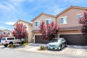 Traditional-style home featuring stucco siding, concrete driveway, an attached garage, and a tile roof