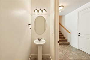 Bathroom featuring baseboards and a sink