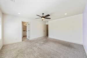 Interior space with ceiling fan, light colored carpet, and baseboards