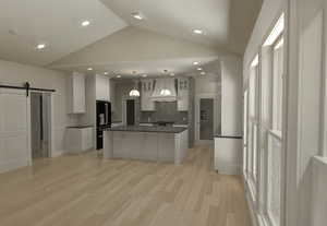 Kitchen featuring a barn door, tasteful backsplash, custom exhaust hood, vaulted ceiling, and dark countertops