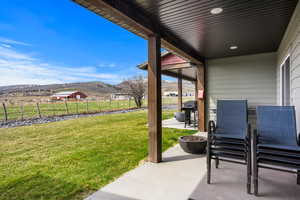 View of patio with a mountain view, a grill, and chairs