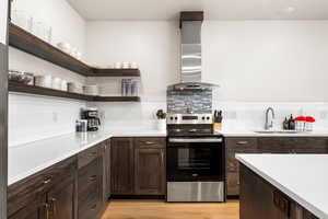 Kitchen with open shelves, beautiful cabinets, electric stove, and wall exhaust hood