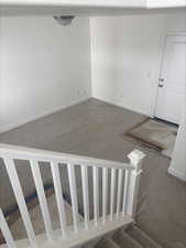 Staircase with baseboards and carpet