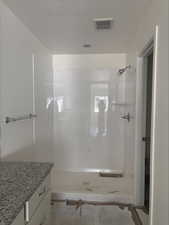 Full bath featuring visible vents, a stall shower, and vanity