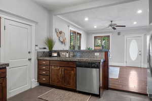 Kitchen featuring stainless steel dishwasher, a sink, a peninsula, ceiling fan, and light tile patterned floors
