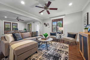Living room featuring arched walkways, a ceiling fan, wood finished floors, plenty of natural light, and recessed lighting