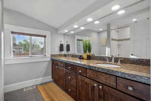 Full bathroom with double vanity, tile patterned floors, recessed lighting, tiled shower, and baseboards