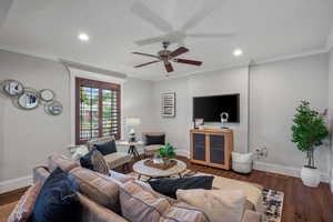 Living room with a ceiling fan, baseboards, recessed lighting, wood finished floors, and ornamental molding