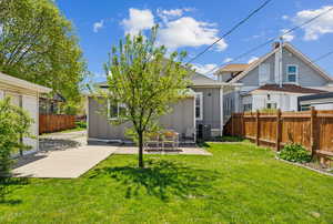 Rear view of property featuring fence, cooling unit, board and batten siding, and a patio