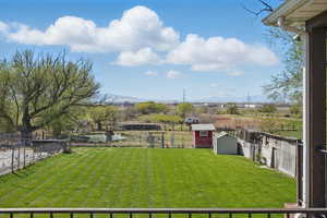 View of yard with a storage shed, fence, and an outbuilding