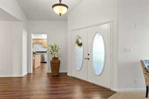 Foyer with baseboards, visible vents, and dark wood-style flooring
