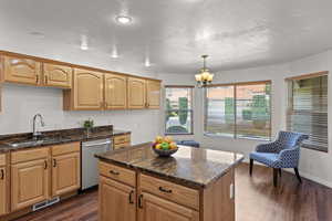 Kitchen with a textured ceiling, a sink, visible vents, a chandelier, and dishwasher