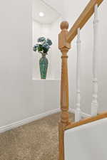Stairway featuring baseboards and carpet floors