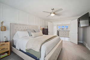 Bedroom with access to outside, a ceiling fan, visible vents, a decorative wall, and light colored carpet
