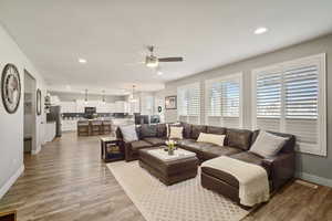 Living area featuring recessed lighting, ceiling fan, baseboards, and light wood-type flooring