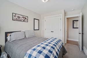 Carpeted bedroom with a closet and baseboards