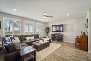 Living area featuring baseboards, recessed lighting, ceiling fan, and light wood-style flooring