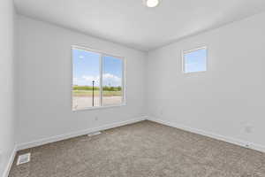 Unfurnished room with carpet, visible vents, and baseboards
