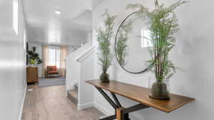 Foyer featuring baseboards, stairway, and wood finished floors