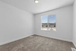 Carpeted empty room featuring visible vents and baseboards