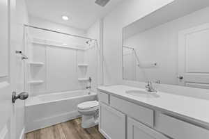 Full bathroom featuring wood finished floors, shower / bathing tub combination, toilet, vanity, and visible vents
