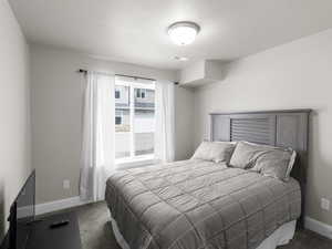 Bedroom with baseboards, visible vents, and dark carpet